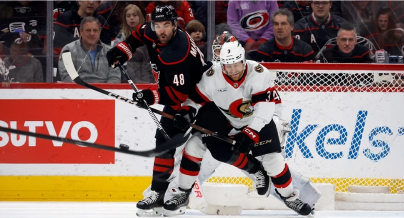 Carolina Hurricanes' Jordan Martinook battles with the Ottawa Senators' Nick Jensen
